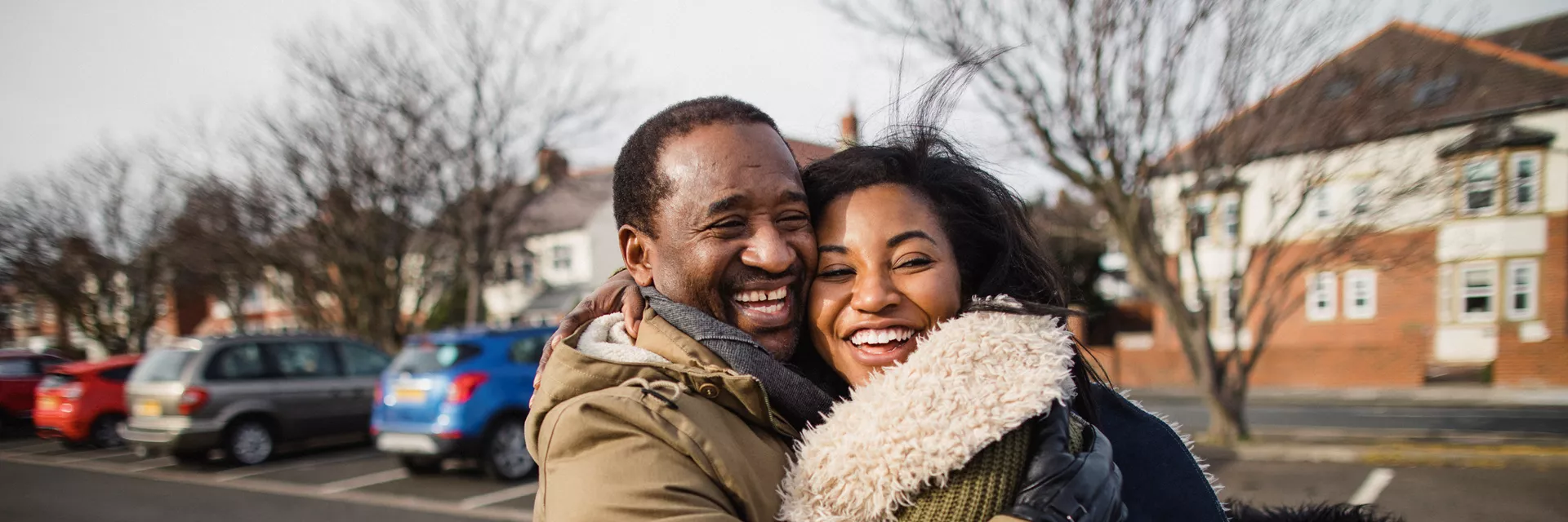 foster couple hugging outside their local ISP fostering agency office