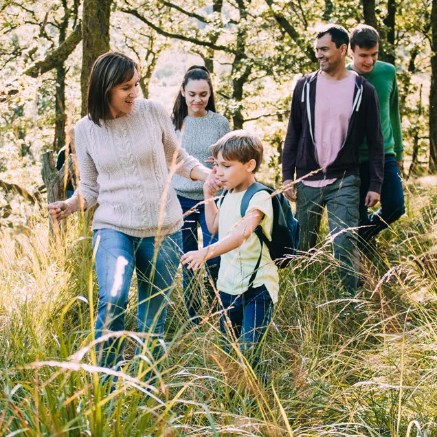 Foster children with foster parents walking through a forest