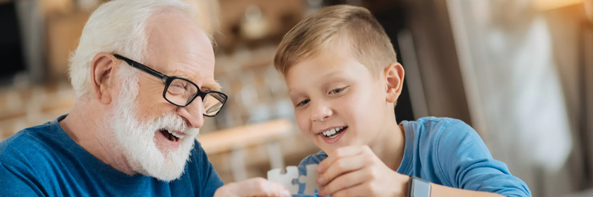 a mature foster parent helping his foster child with a jigsaw